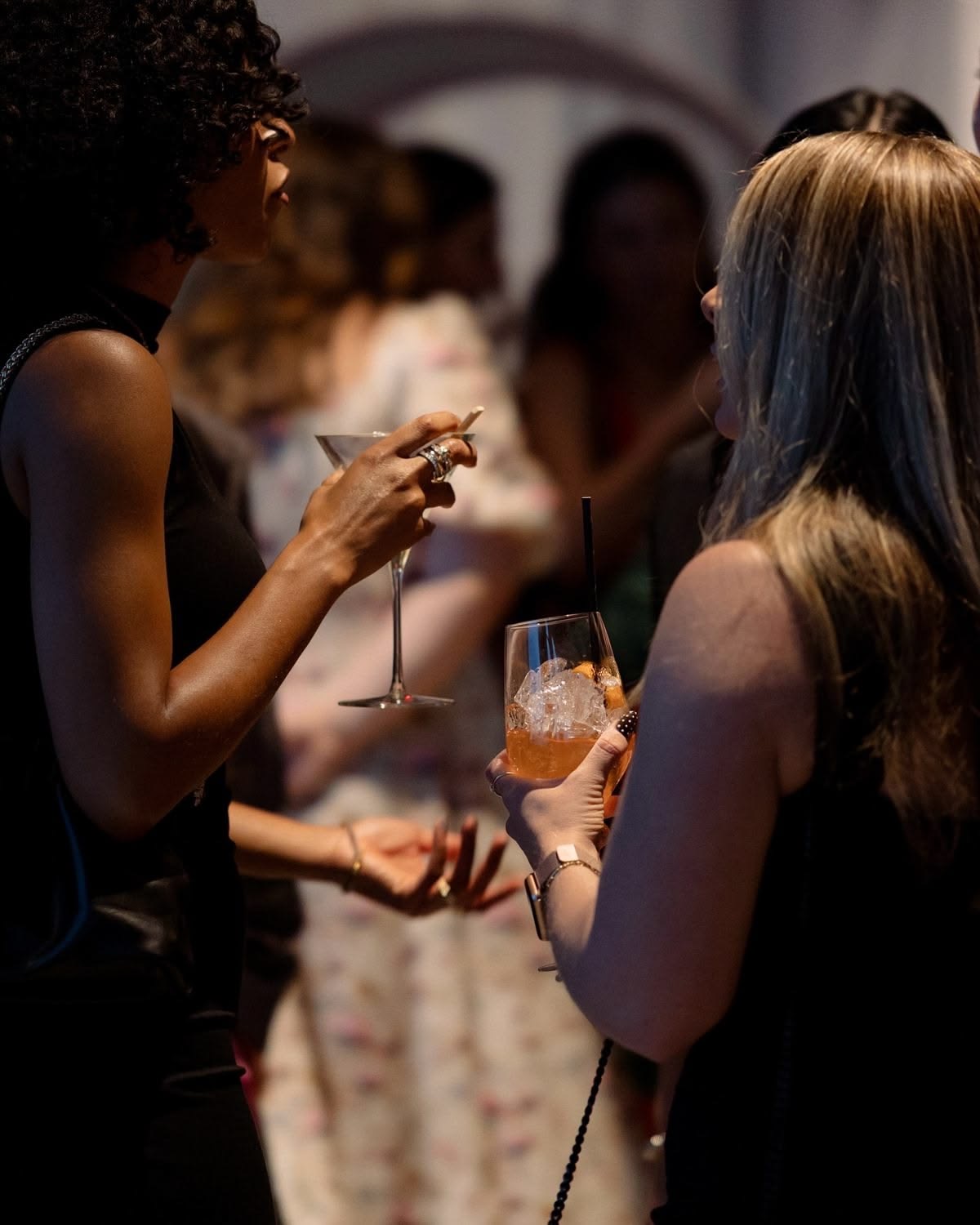 A host carefully arranging elegant small-bite cups in a warm, intimate setting with soft ambient light